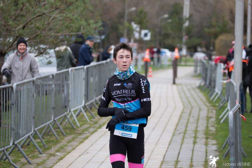 jeune adolescent sur la ligne d'arrivée de la course trail des 2 baies Ado.